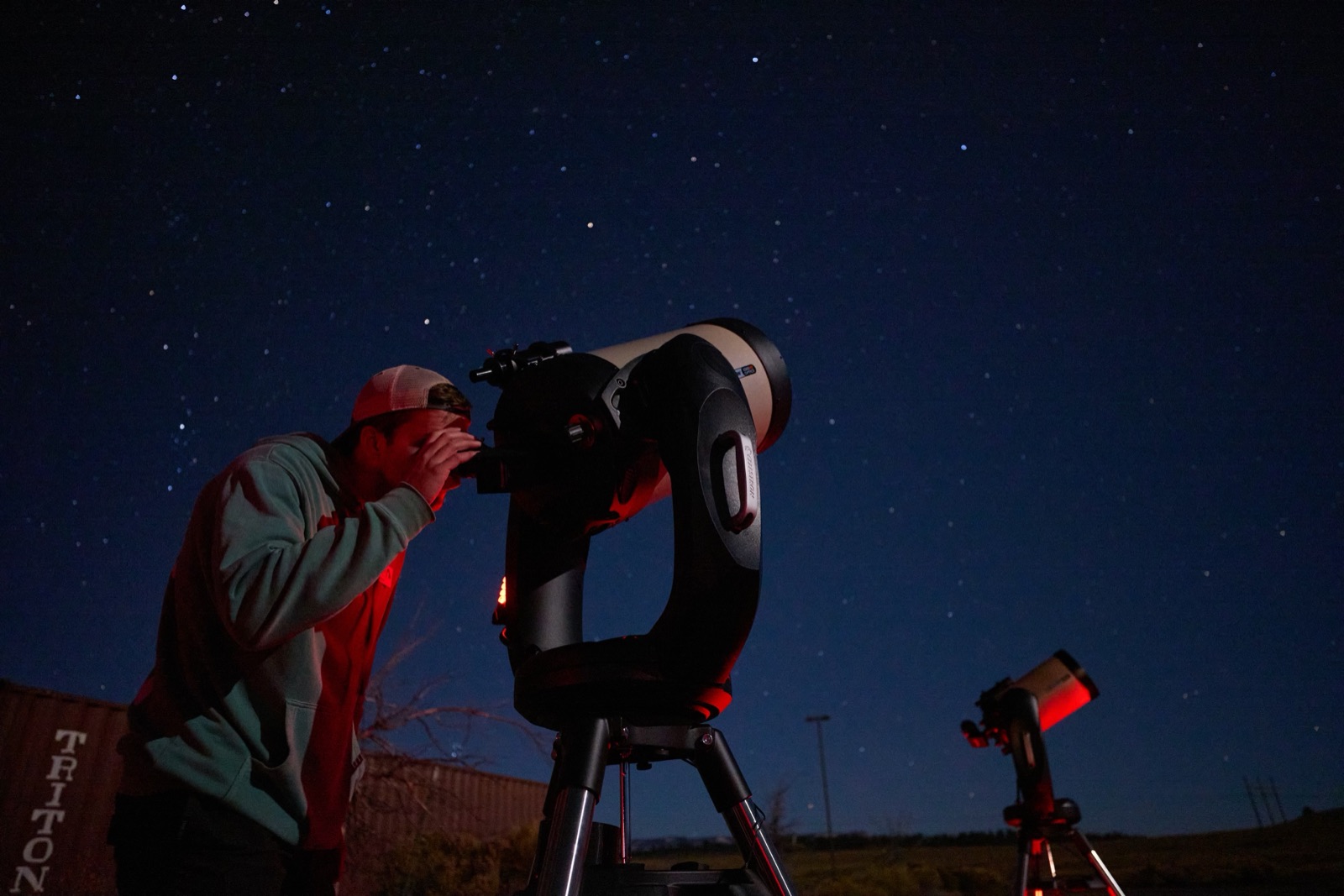 Guest looking through a telescope under a starry sky on a Bryce Canyon Stargazing tour