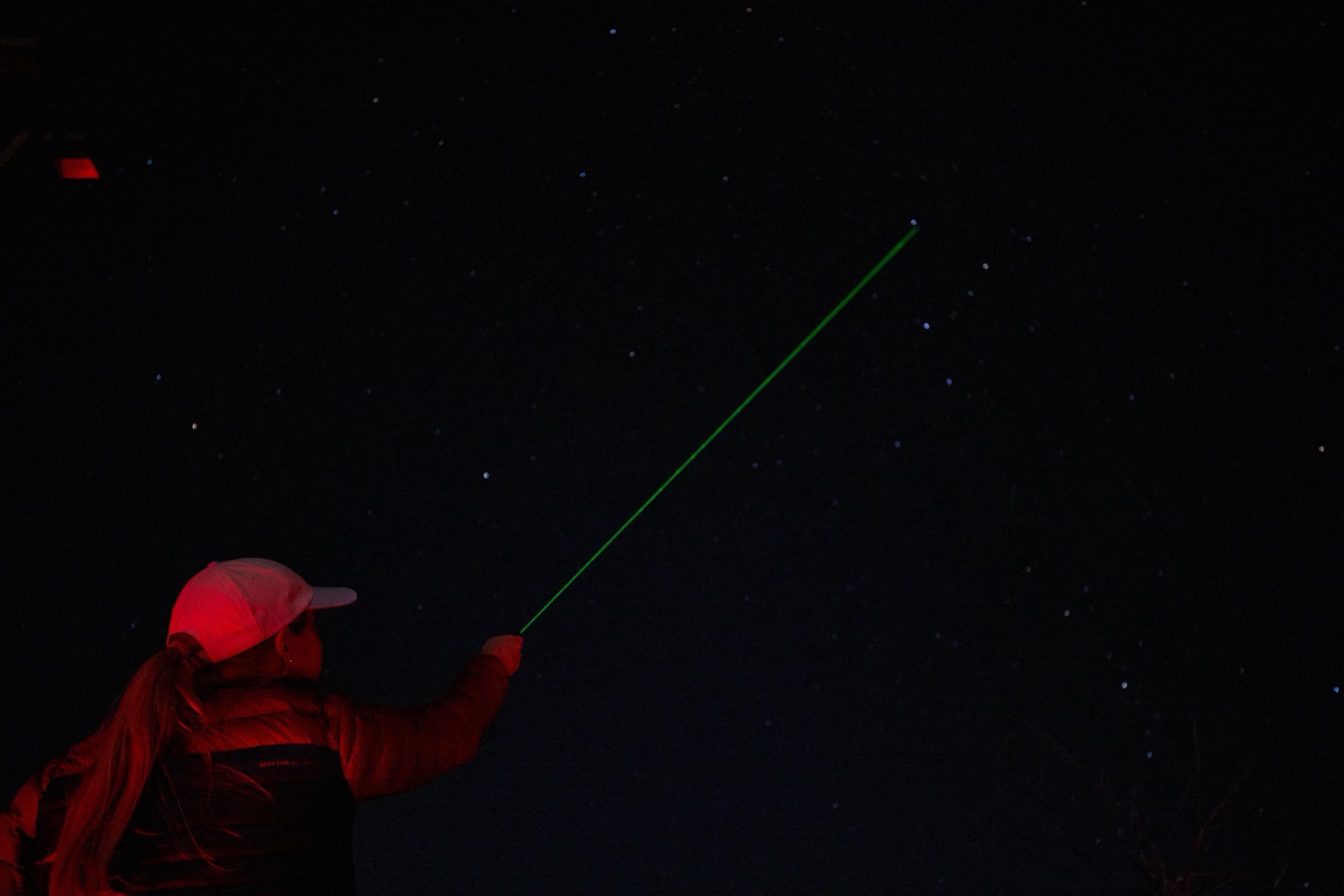 Guide pointing a green laser at constellations during a Bryce Canyon Stargazing night tour